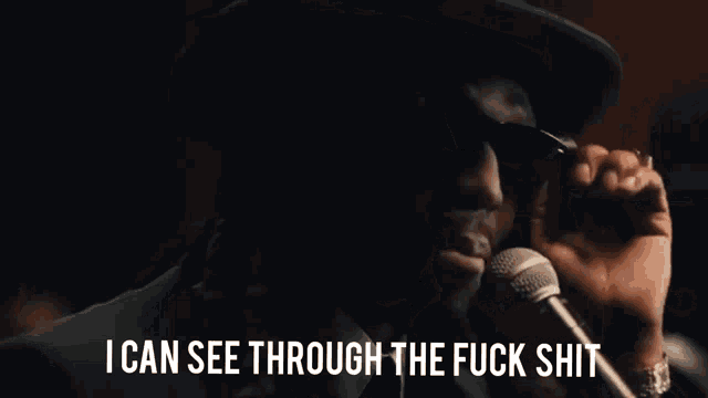 a man singing into a microphone with the caption i can see through the fuck shit
