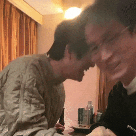 two men are sitting at a table with a can of diet coke on the table