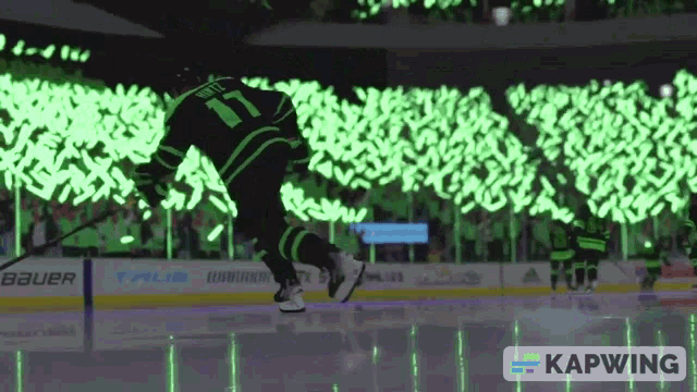 a hockey player wearing a green jersey with the number 17 on it