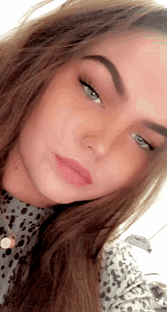 a close up of a woman 's face with a leopard print top