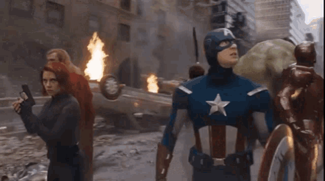 a group of avengers including captain america and black widow are walking through a destroyed city