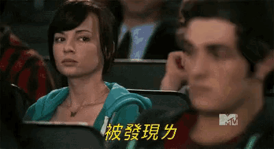a man and a woman are sitting in a theater with a mtv logo in the corner