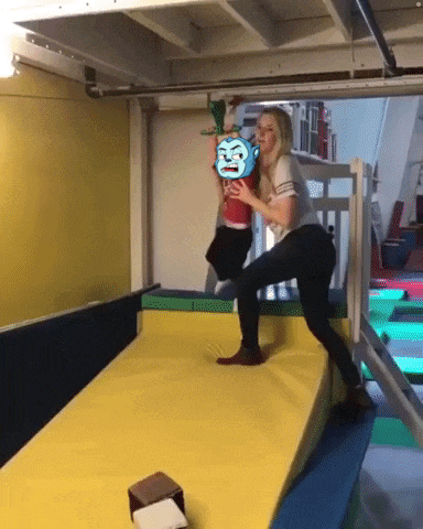 a woman is holding a child on a yellow mat with a picture of a monkey on it