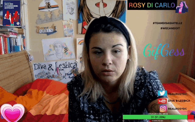 a woman is sitting in front of a wall with drawings and a sign that says diva & lesbica