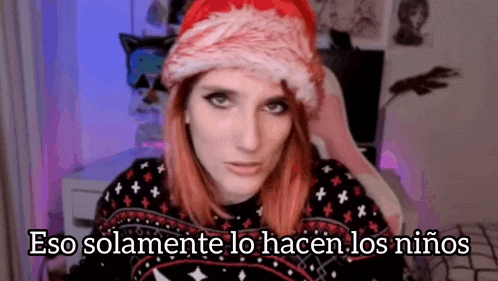 a woman with red hair wearing a santa hat and a sweater is talking on a video call .