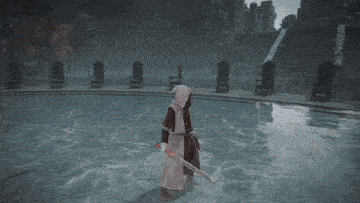 a person is holding a sword in a video game while standing in a pool of water .