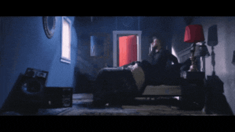 a person laying on a bed in a room with an open door