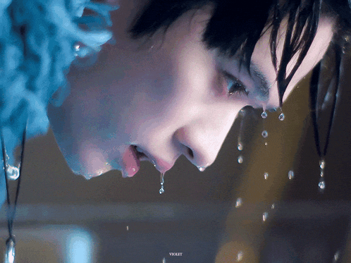 a close up of a person 's face with water coming out of their mouth
