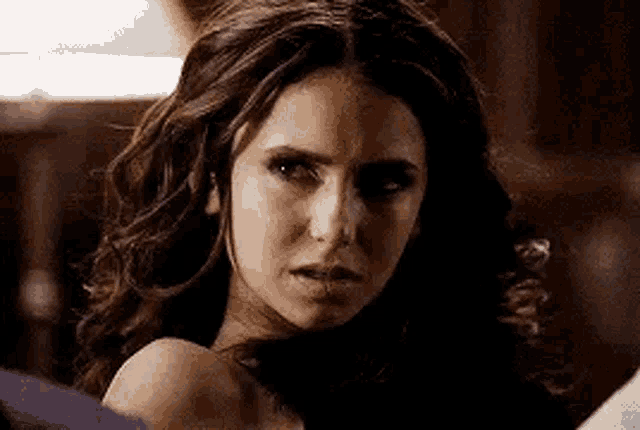 a close up of a woman 's face with a serious expression .