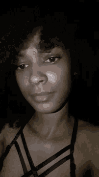 a woman in a black bra is laying on her back with her hands on her face