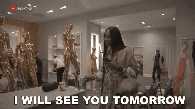 a woman is standing in a room with mannequins and says i will see you tomorrow .