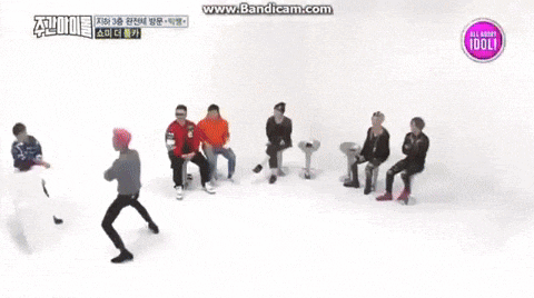 a group of young men are dancing in front of a sign that says all about idol