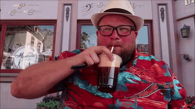 a man drinking from a plastic cup with a straw