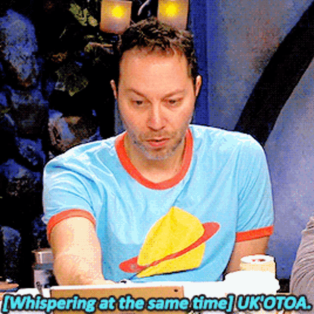 a man in a blue t-shirt is whispering at the same time uk otoa