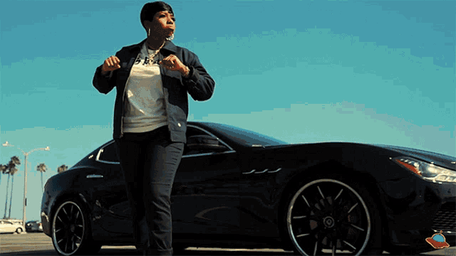 a woman stands in front of a black car with a sticker on the side that says ' a '