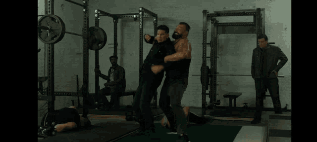 two men are fighting in a gym and one of them is holding another man 's arm