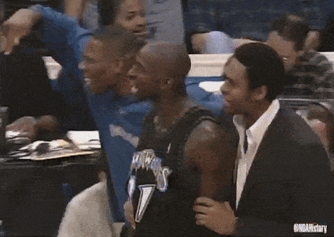 a group of basketball players are standing around each other in a crowd .