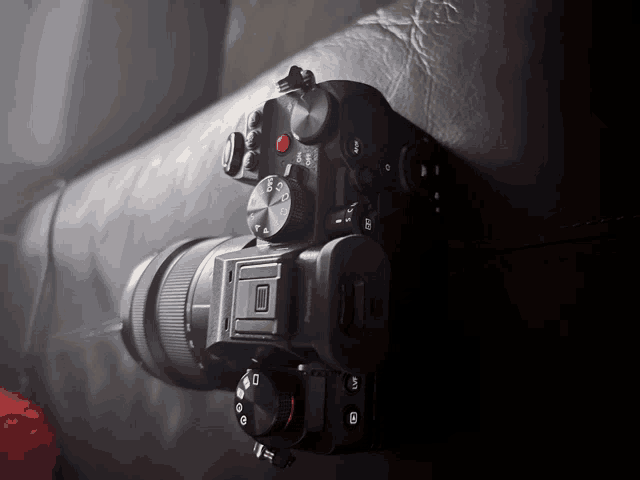 a black camera with a red button that says shutter