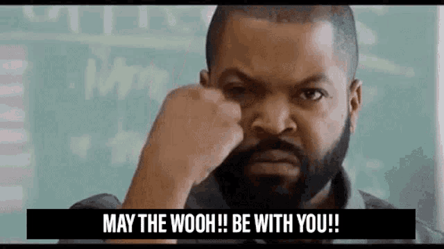 ice cube is making a funny face while holding his fist to his face .