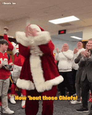 a man in a santa suit is dancing in front of a crowd with the caption how ' bout those chiefs '