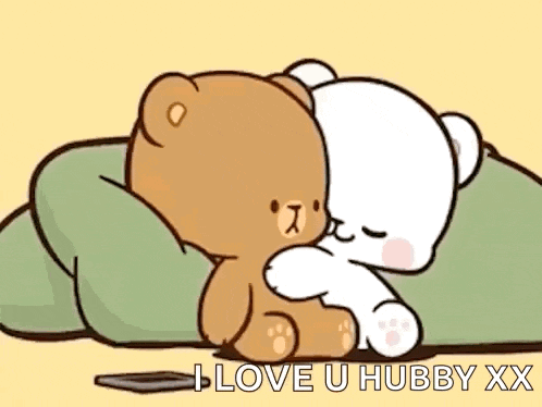a couple of teddy bears are hugging each other while laying on a pillow .