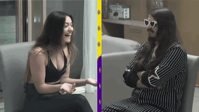 a man and a woman are sitting on a couch laughing .