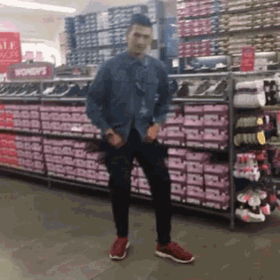 a man standing in a shoe store with a sign that says women 's on it