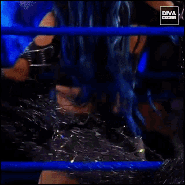 a woman with blue hair is standing in front of a sign that says " diva girls "