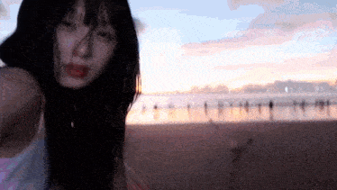 a woman is taking a picture of herself on the beach at sunset