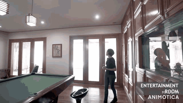 a woman stands in a room with a pool table and the words entertainment mroom animatica