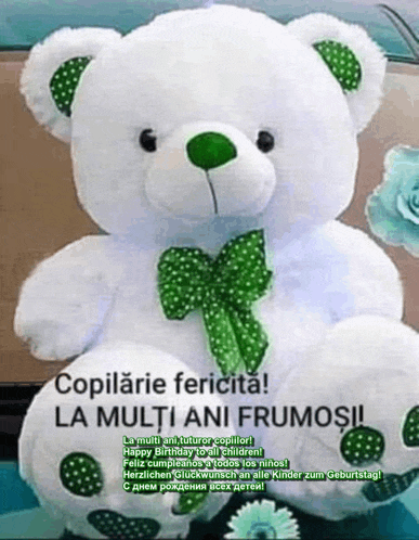 a white teddy bear with a green bow and polka dots