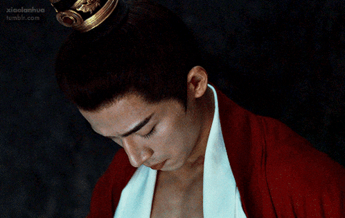 a man with a crown on his head is looking down at his torso