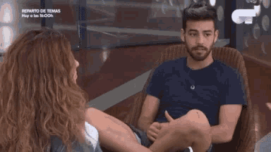 a man and a woman are sitting in chairs and talking