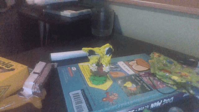 a dog man book sits on a table next to a crayon box
