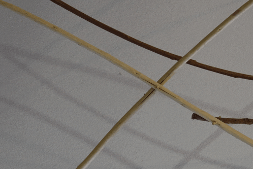 a white wall with a few sticks crossed
