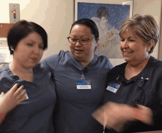three nurses are posing for a picture and one of them has a name tag that says ' amanda ' on it