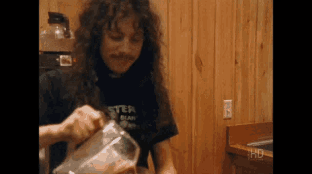 a man with long hair wearing a black shirt that says ' ster '