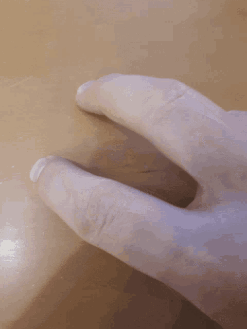 a close up of a person 's hand with a white nail