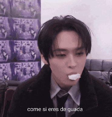 a man in a suit and tie is eating something with the words come si eres de guada in the corner