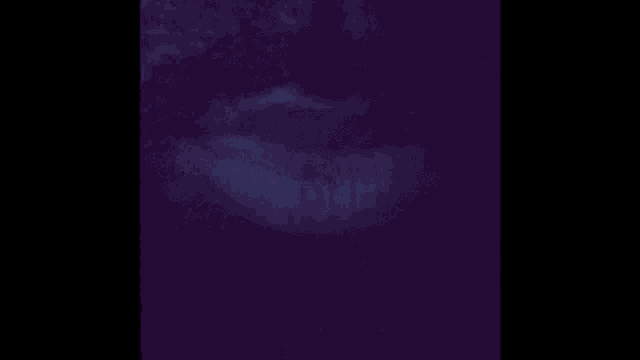 a close up of a person 's face in the dark