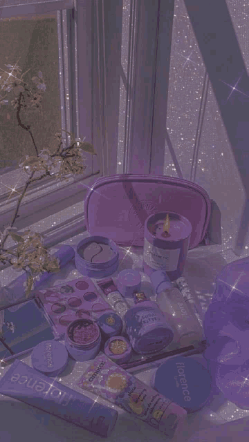 a table with purple cosmetics and a candle with florence written on it