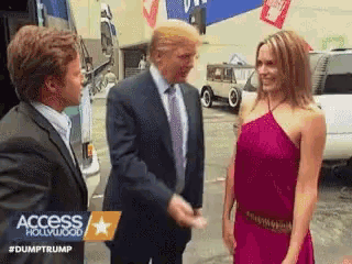 a man in a suit and tie talks to a woman in a red dress