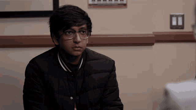 a man wearing glasses and a black jacket