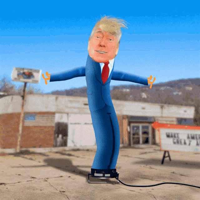 a donald trump inflatable is standing in front of a make america great again sign