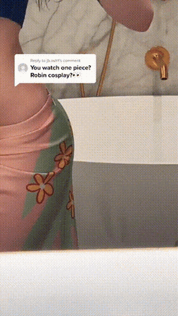 a woman is taking a picture of herself in a bathroom mirror with a comment asking if she watched one piece robin cosplay