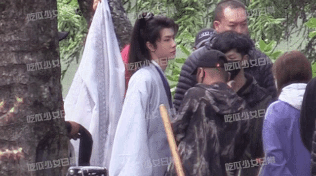 a group of people are standing in a park with chinese writing on their shirts