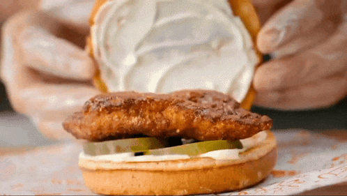 a close up of a chicken sandwich with mayonnaise on top
