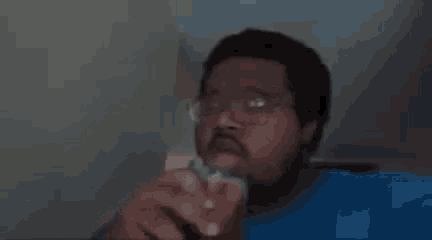 a man with a beard and glasses is holding a glass of water and saying `` that shit good '' .