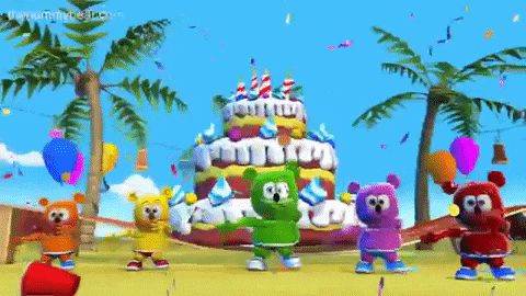 a group of gummy bears are dancing in front of a cake