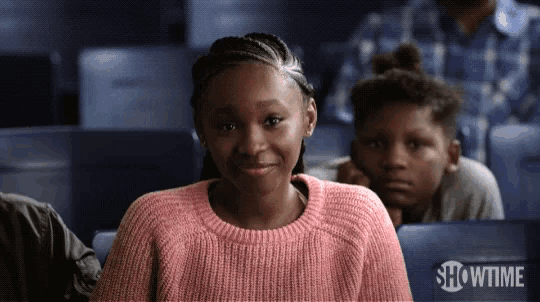 a girl in a pink sweater is sitting in a showtime theatre